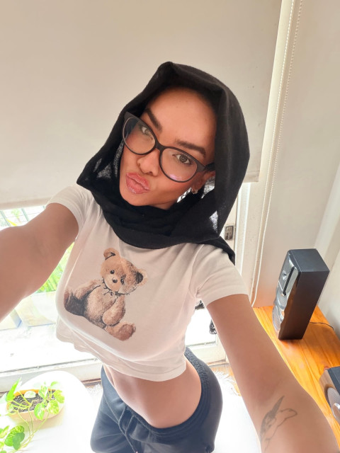 Ein Mädchen macht „SFW“-Selfies, während sie einen Hidschab und eine Brille trägt