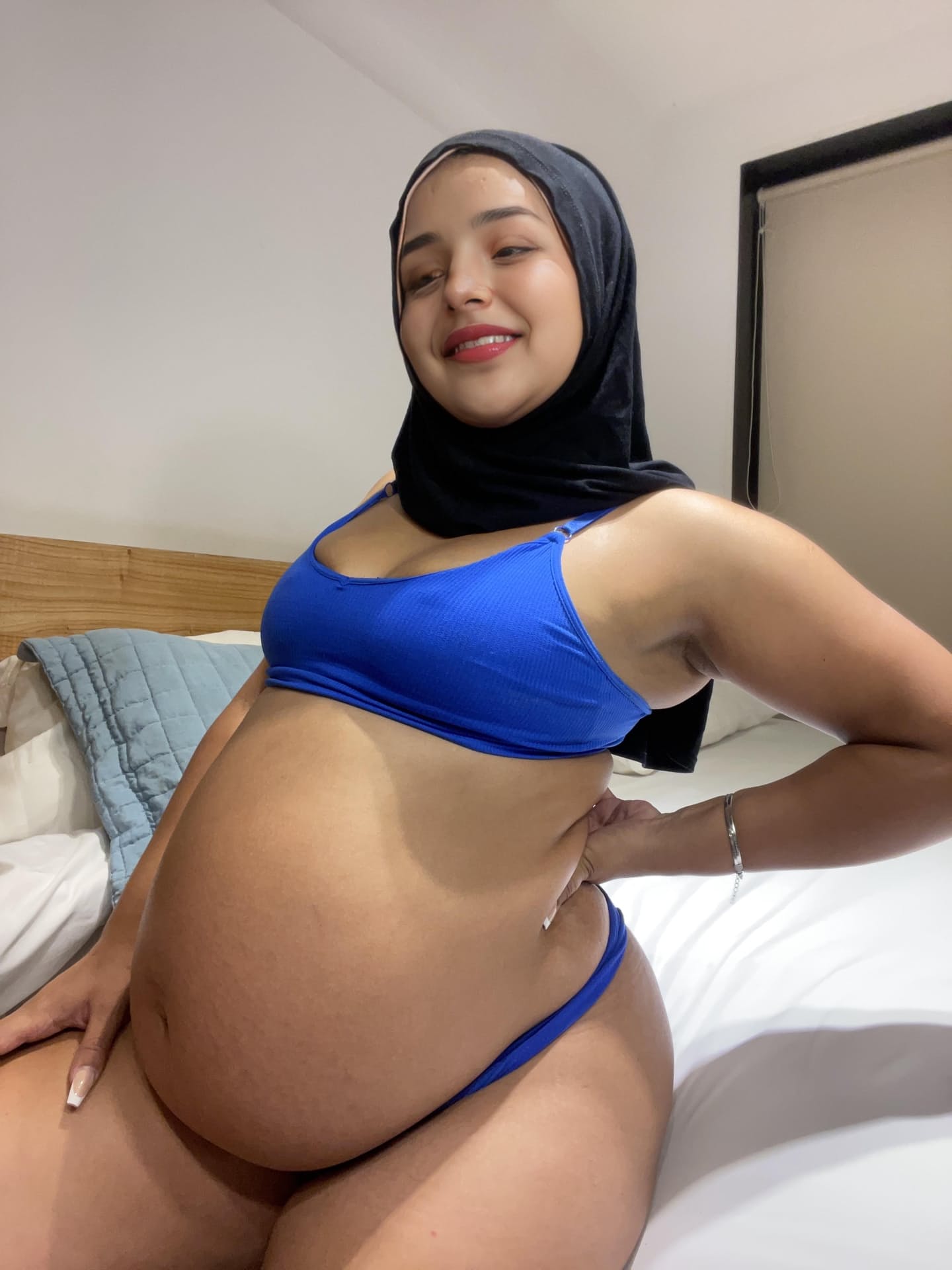 Ein Model aus dem Nahen Osten zeigt ihren riesigen Bauch, während sie einen schwarzen Niqab trägt